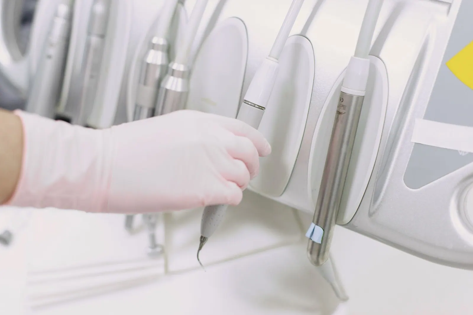 Close-up of a gloved hand operating dental tools in a sterile clinic environment. Cost of Dental Marketing in Canada: What Practices Actually Pay in CAD