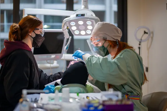 Dentist and assistant performing dental procedure in a well-equipped clinic. Cost of Google Ads for Dentists: What a Real Budget Looks Like