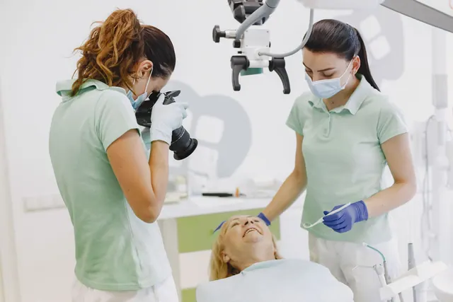 Dentists with hygienic gear assisting a patient in a professional dental clinic, ensuring comfort and care. Dental advertising: a practical guide for 2027