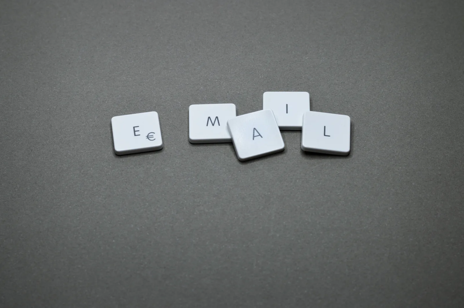 Close-up of the word 'email' formed with letter tiles on a gray surface. Dental email marketing trends: the shifts that matter