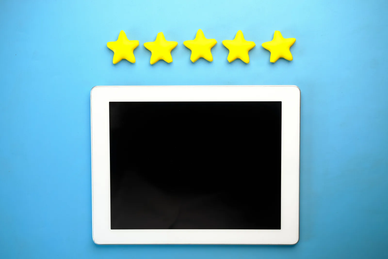 Tablet with five yellow stars on a blue background, ideal for rating concepts. Dental reputation management tools for people who want the details in 2027