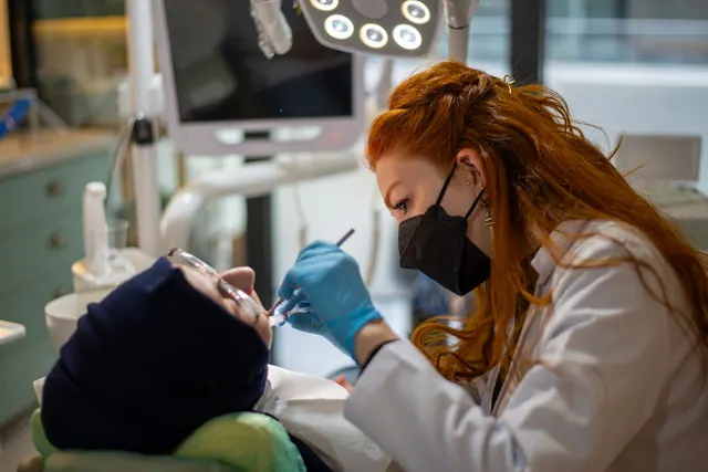 A female dentist focused on treating a patient in a modern, well-equipped dental clinic. Dental SEO: a focused business guide for 2027