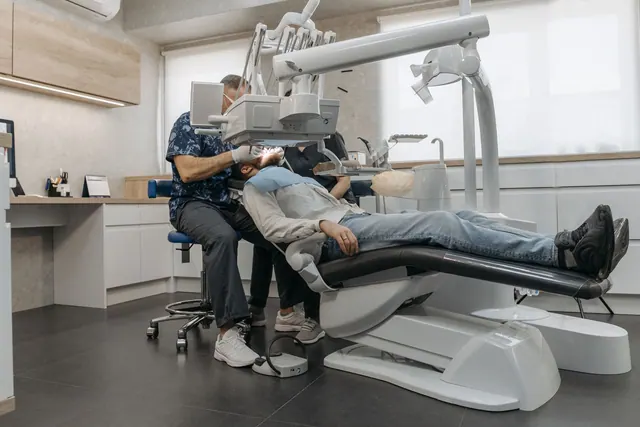 A dentist examines a patient using advanced dental equipment in a modern clinic setting. How to Rank in Google Maps for 'Dentist Near Me' Without Paid Ads