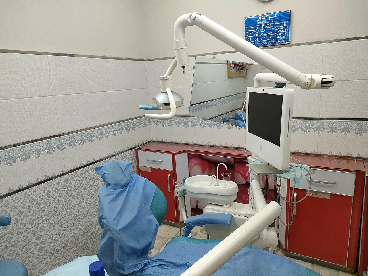 A dental chair and clinical monitor in a treatment room.