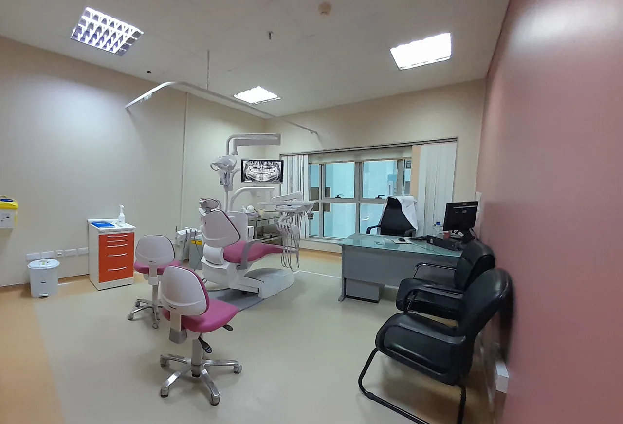 A dental operatory with treatment chairs, equipment, lighting, and a desk in Dubai.